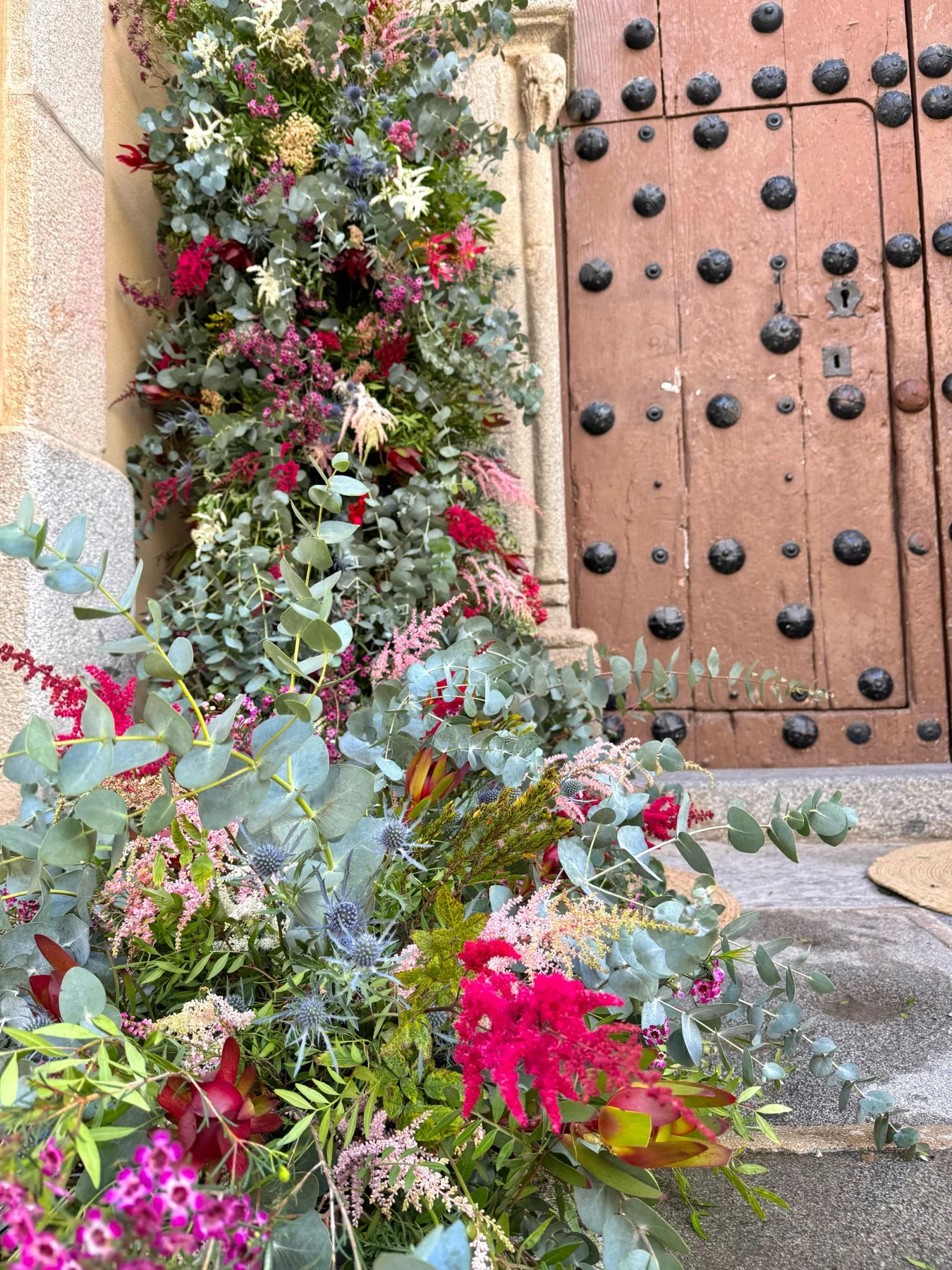 Composición floral junto a una puerta